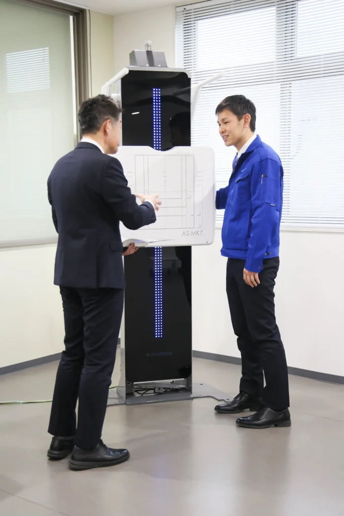 レントゲン撮影装置について説明する社員